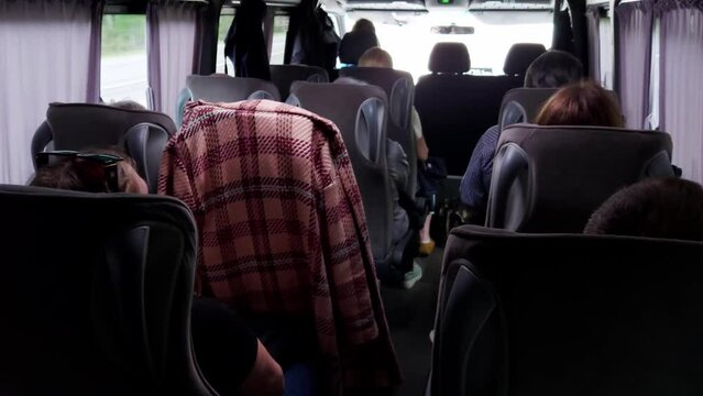 Passengers travel in an intercity minibus outside the city, view from the inside. Relocation and travel concept.