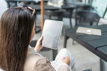 Caucasian white businesswoman using digital tablet checking stock market and exchange in coffee...