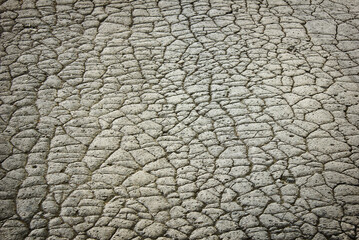 gray background with cracked old road. Texture of cracked asphalt close-up.