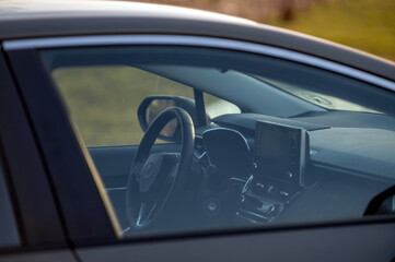 Close up of a car interior with steering wheel and speedometer. Selective focus.