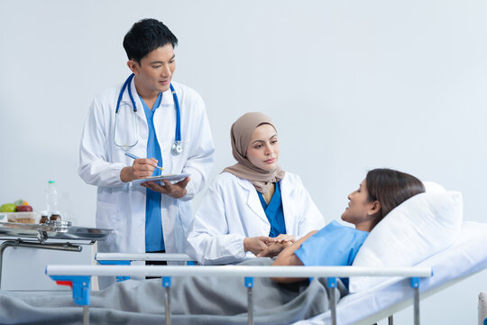 Two conficent doctor or specialist of kidney cancer talking together with female mix race patient on bed at medical ward, checkup, recovering after successful surgery concept.