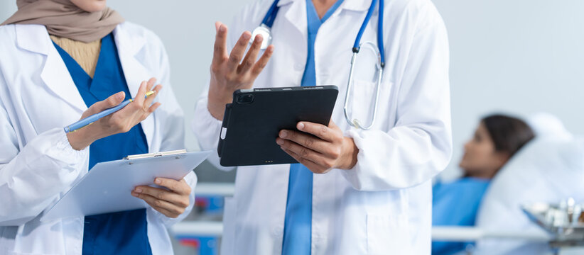 Two conficent doctor or specialist of kidney cancer talking together with female mix race patient on bed at medical ward, checkup, recovering after successful surgery concept.