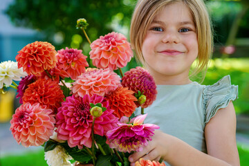 Close up of little preschool girl with dahlia flower bouquet. Close-up of happy child holding...