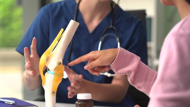 Knee model showing the process of osteoarthritis and knee arthroplasty, doctors explaining symptoms and treatment to patients.