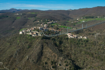 View of the Tibetan bridge joins Sellano, one of Italy's most beautiful medieval villages, to the hamlet of Montesanto, with a thrilling crossing suspended in the air - 763926526