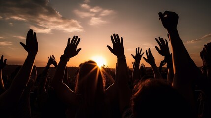 A group of people captured in silhouette, raising their hands in celebration against the warm glow of a setting sun, conveying a sense of freedom and joy