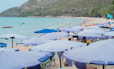 People on the sea beach with sunbeds and umbrellas. hot sunny summer day