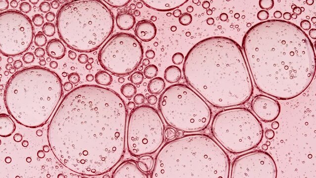 Bubble cluster, cells under a microscope. Transparent cosmetic gel fluid with molecule bubbles oil distribution. Macro Shot of Natural Organic Cosmetics, Medicine. Production Close-up. Slow Motion. 