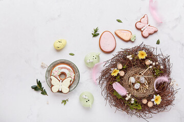 Easter table setting decorations - nest and pastel Easter cookies on white background aesthetics