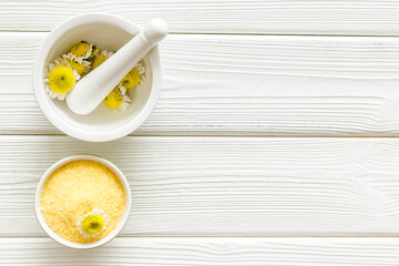 White mortar with pharmacy chamomile flowers for skin care spa products
