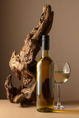 White wine and old snag on a beige background.