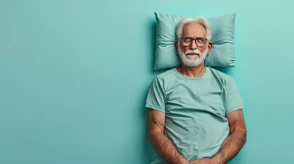 Poster Elderly man sleeping on pillow isolated on pastel blue colored background Sleep deeply peacefully rest. Top above high angle view photo portrait of satisfied .senior wear blue shirt © Sittipol 