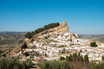 Old town Montefrio. The ruins of a Moorish castle on a rock and white houses under cloudless sky....