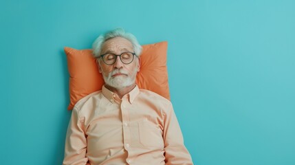 Elderly man sleeping on pillow isolated on pastel blue colored background Sleep deeply peacefully rest. Top above high angle view photo portrait of satisfied .senior wear orange shirt