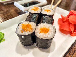Sushi rolls with fresh ingredients served on a platter. Japanese Sushi Rolls on White Plate With Ginger Garnish. Blurred and Partial focus