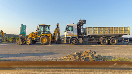 Backhoe Loader Machine and Dump Tipper Truck Highway Construction Site
