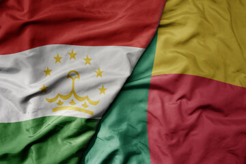 big waving national colorful flag of benin and national flag of tajikistan.