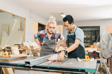 In a carpenter's shop, skilled craftsmen engage in woodwork, creating furniture with tools in a...