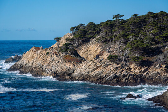 A rocky shoreline with a body of water in the background