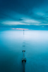 Obraz premium Vertical of a foggy landscape at cloudy sunset