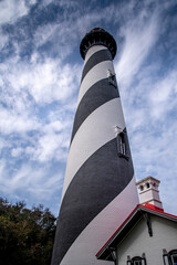 Lighthouse at St. Augustine, tall black and white striped lighthouse on the Atlantic Coast of Florida, Lighthouse grounds with blue skies and clouds