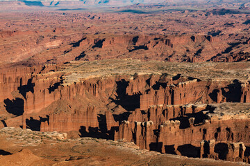 A desert landscape with a canyon in the background