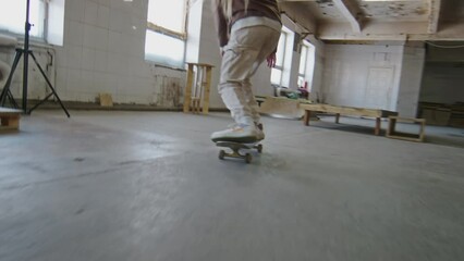 Female skateboarder performing ollie over obstacle trick while training skills at indoor skatepark