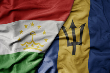 big waving national colorful flag of barbados and national flag of tajikistan.