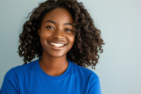 Portrait of a beautiful young african american woman smiling against grey background