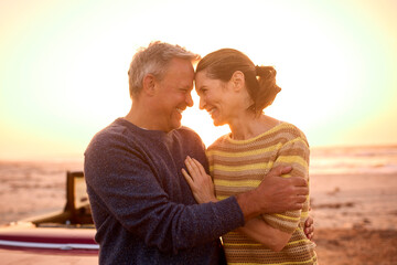 Loving Retired Senior Couple On Vacation Next To Classic Sports Car At Beach Watching Sunrise - 763979929