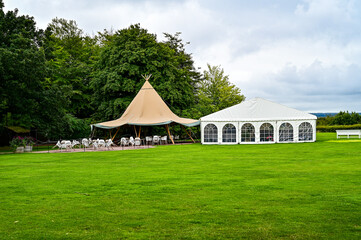 Wedding location on a green meadow with tipi, chairs and white pavilion in Sofiero Palace Gardens...