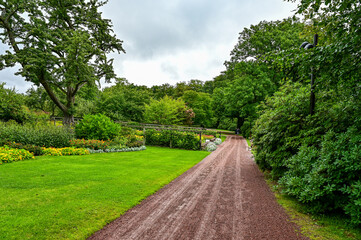 Fototapeta na wymiar Sofiero Palace Gardens, green park with paths and large trees in Sofiero Castle, Sofiero Slott och Slottsträdgard as a tourist attraction in Helsingborg, Sweden 