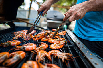 A person is grilling prawns on an outdoor grill. A male chef cook. Healthy seafood. Delicious and tasty shrimp.