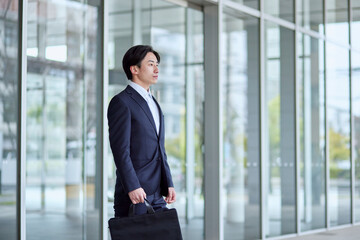 オフィスビルとスーツを着た若い日本人ビジネスマン