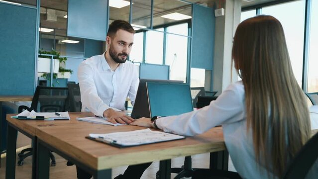 In love, holding hands. Man and woman employees are working in the office.