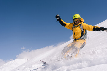 female snowboarder riding on slope of powdery snow in high mountains. Freeride at ski resort,...