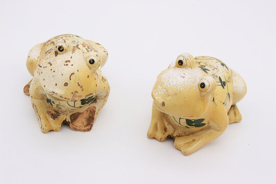Image of two porcelain toys in the form of frogs on a light background.