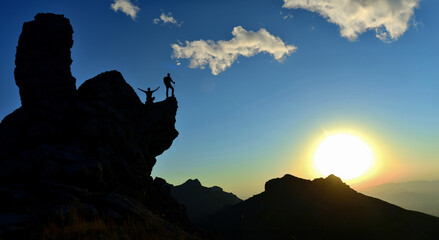 two climbers feel peace in a wonderful place at sunrise time - 763991508