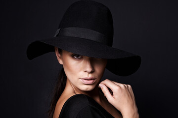 Woman, portrait and fashion hat with mystery beauty on black background with makeup cosmetics,...