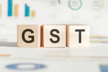 Wooden Blocks Spelling the Acronym GST on Table