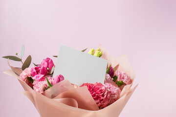Bouquet of flowers with card, floral arrangement, pink roses, message for celebration.