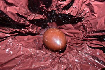 uovo di pasqua dentro la sua confezione di carta stagnola durante l'apertura di esso