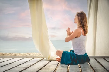 Poster Woman meditating at the sea © nickolya