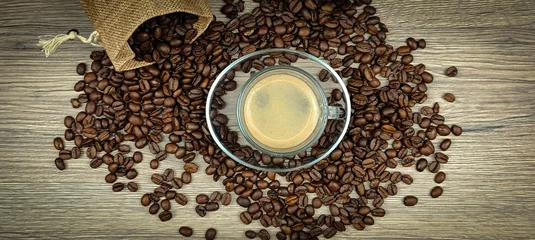 Raamstickers tasse de café et grains de café étalés sur une table, en gros plan  © ALF photo