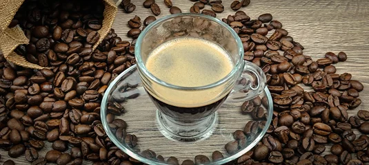 Foto op Plexiglas tasse de café et grains de café étalés sur une table, en gros plan  © ALF photo