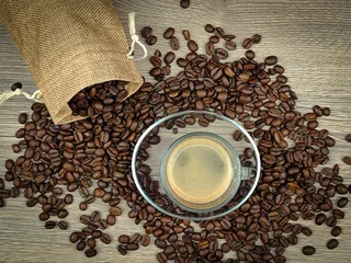 Foto op Plexiglas tasse de café et grains de café étalés sur une table, en gros plan  © ALF photo