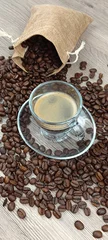 Zelfklevend Fotobehang tasse de café et grains de café étalés sur une table, en gros plan  © ALF photo