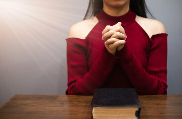 Christian woman sitting and praying to God Praise the Lord Then a light shone down. - obrazy, fototapety, plakaty