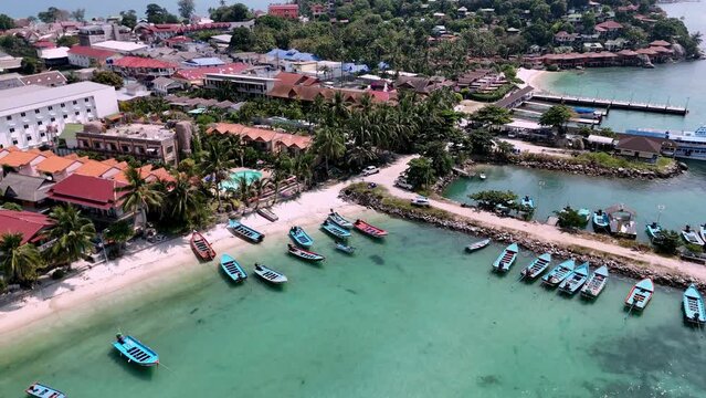 Aerial view of Haad Rin District and Haad Rin Pier (Haad Rin Queen Ferry) in Koh Phangan, Thailand. Revealing backward drone shot.  