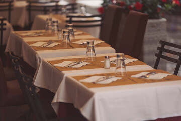Beautiful tables in a street cafe in rainy day, Milano, Italy. Street view of a coffee terrace with tables and chairs in europe. 